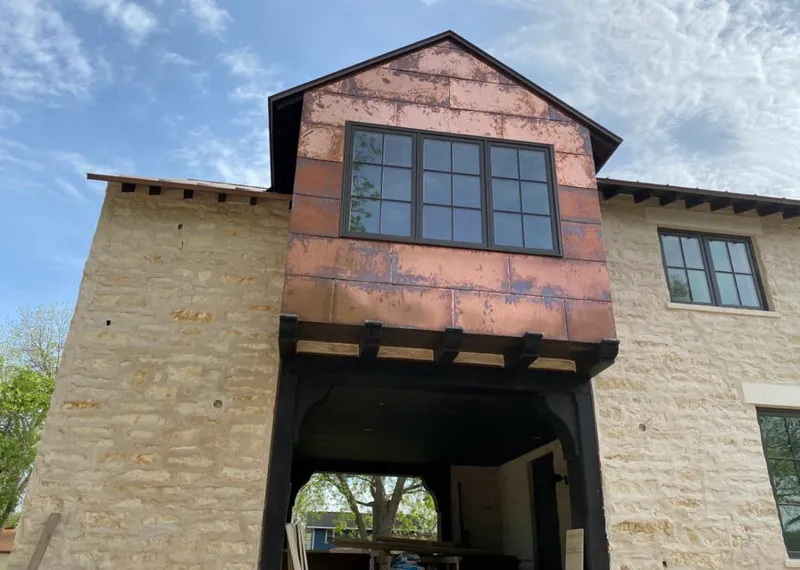 Copper metal panel facade on a stone building for Roof Repair in Morris